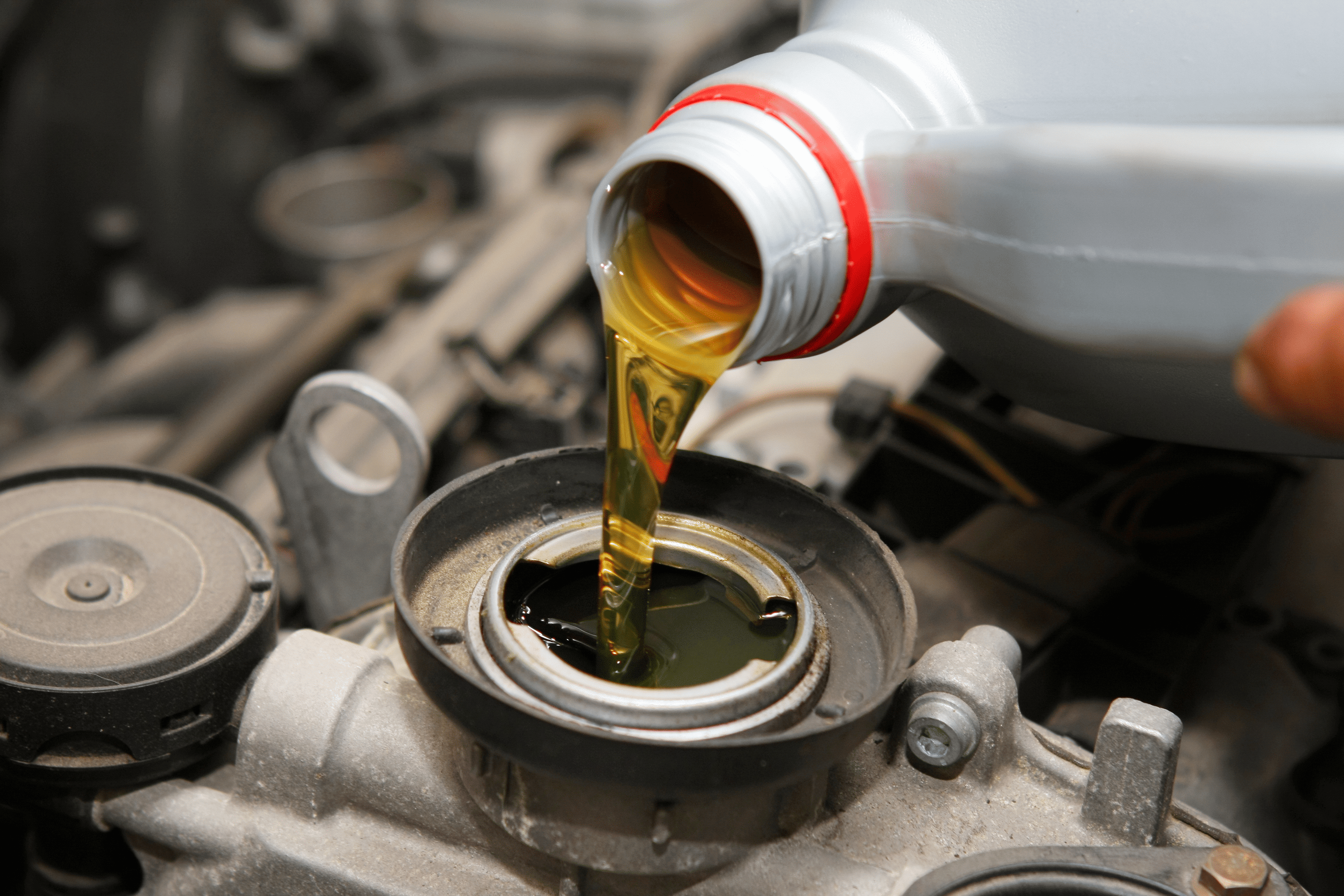 oil pouring form a bottle into an engine