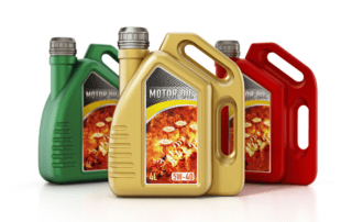 Three jugs of engine oil in green, gold, and red